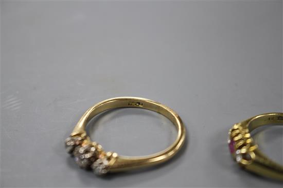 A modern 18ct gold, ruby and diamond set three stone ring and an 18ct and three stone diamond ring,